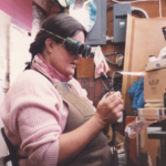 Pregnant Cathy Callihan creating metal art in her workshop, 1988